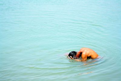 View of man dunking head in sea