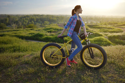 Woman with bicycle on grass