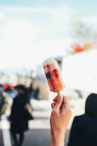 Close-up of hand holding ice cream against blurred background