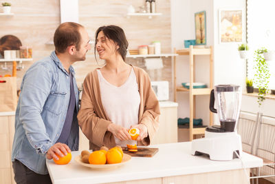 Man and woman standing by fruits