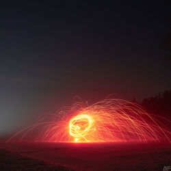 Light trails on field against sky at night