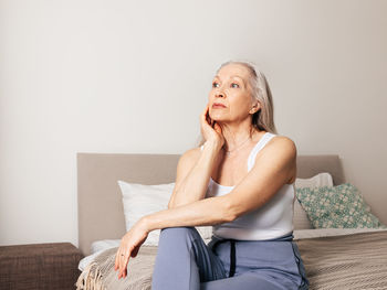 Young woman sitting on sofa at home