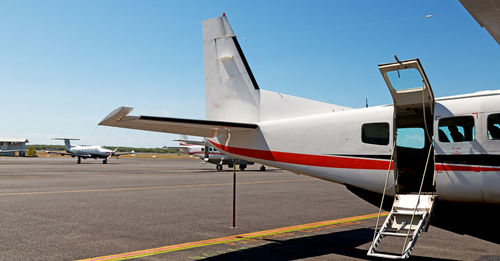 Airplane on airport runway against sky