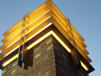 Low angle view of yellow building against blue sky