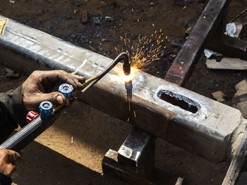 Metal work. man cuts a hole in a steel piece using gas welding