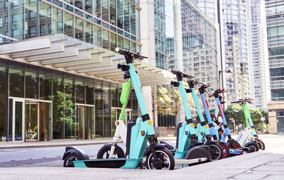 Electric push scooters parked in front of buildings