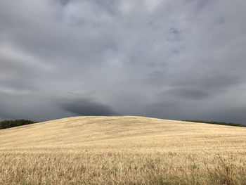 Scenic view of field against cloudy sky