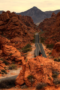 Rear view of man standing on rock formations