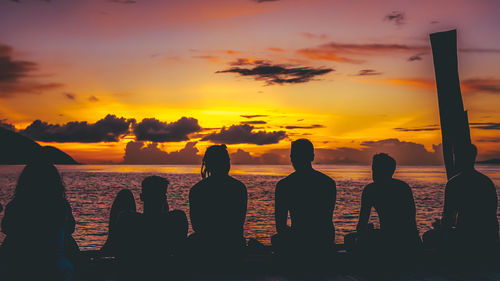 Silhouette people at beach during sunset