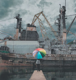 Man by harbor against sky in city