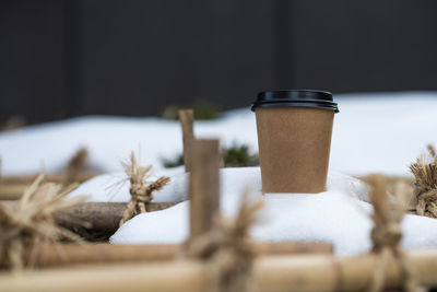 Close-up of disposable coffee cup on snow