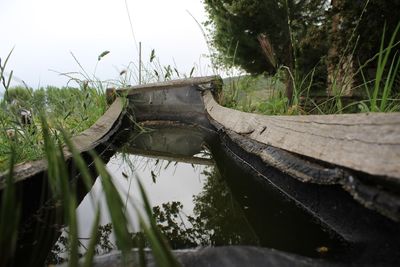 Close-up of abandoned boat against grass