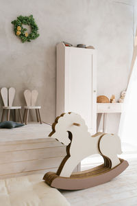 White wooden rocking horse in children room