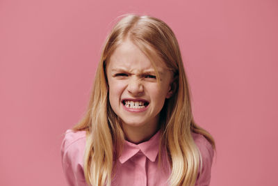 Portrait of young woman against yellow background