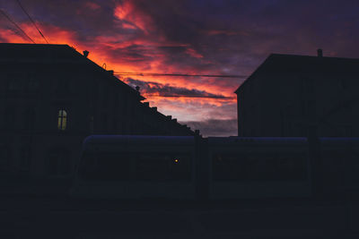 Silhouette built structures against cloudy sky