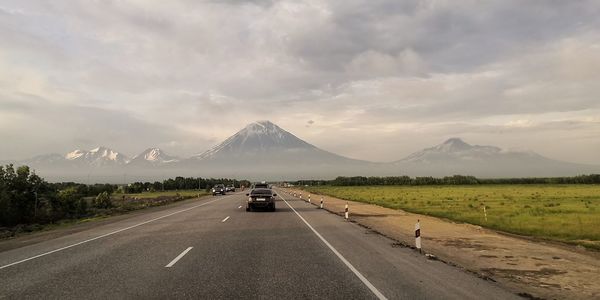 Vehicles on road against mountain range