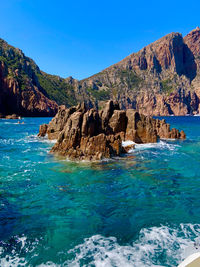 Scenic view of rocks in sea against sky