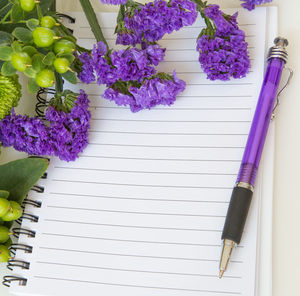 Blank notebook, pan with beautiful purple blue statice flower and green flower.