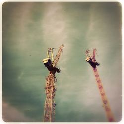 Low angle view of crane against sky