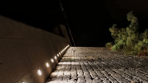 Footpath by wall at night