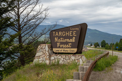 Information sign on landscape against sky