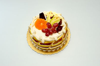 Close-up of strawberry cake on table against white background