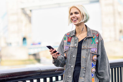 Smiling young woman using mobile phone