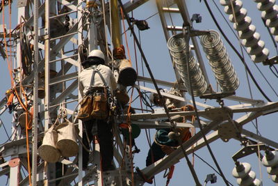 Maintenance engineers repairing electricity pylon