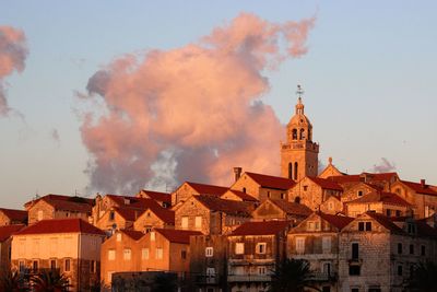 Church with townscape against sky during sunset