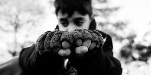 Close-up of boy hands showing fists outdoors