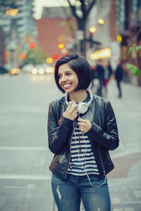 Smiling young woman standing on street