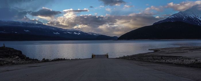 Scenic view of lake by mountains against sky