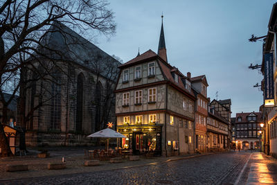 Street amidst buildings in town at dusk