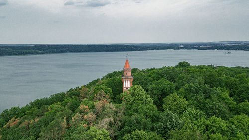 Scenic view of building by sea against sky