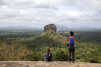 Rear view of woman looking at mountain against sky