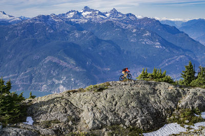 Man climbing on mountain against sky