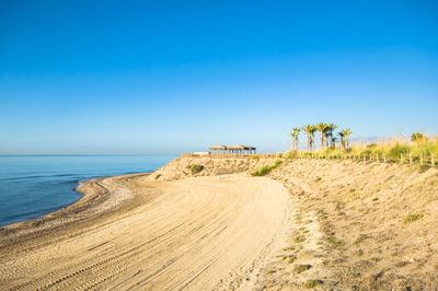 Scenic view of beach against clear blue sky