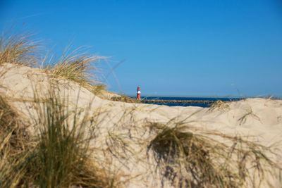 Scenic view of beach against clear blue sky