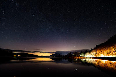 Scenic view of lake against sky at night