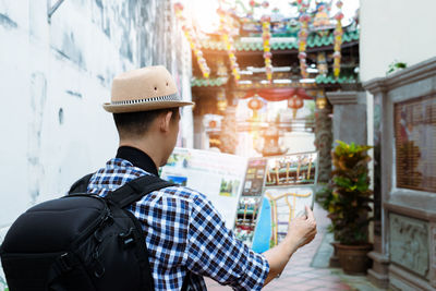 Rear view of man holding map