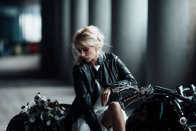 Young woman sitting with umbrella