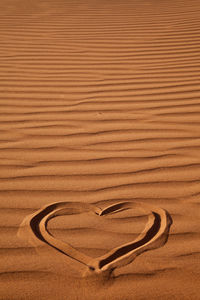 High angle view of heart shape on sand