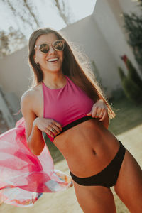 Portrait of smiling sensuous young woman wearing sunglasses