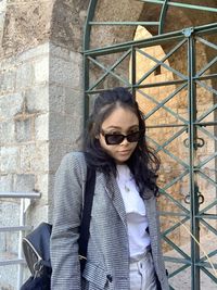 Portrait of young woman wearing sunglasses standing outdoors