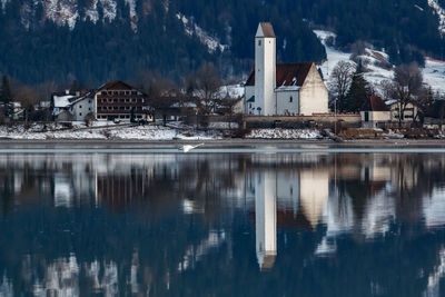 Reflection of buildings on lake during winter