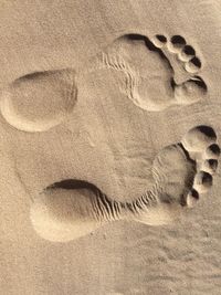 Close-up of footprints on sand at beach