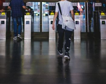Rear view of men walking at underground subway station