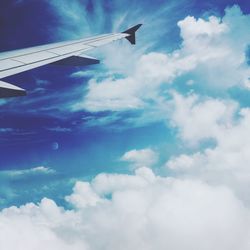 Low angle view of airplane wing against cloudy sky