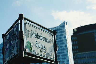 Low angle view of information sign against sky