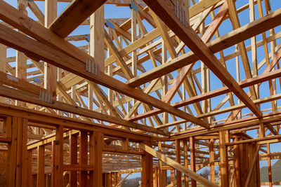 Low angle view of roof beams against sky